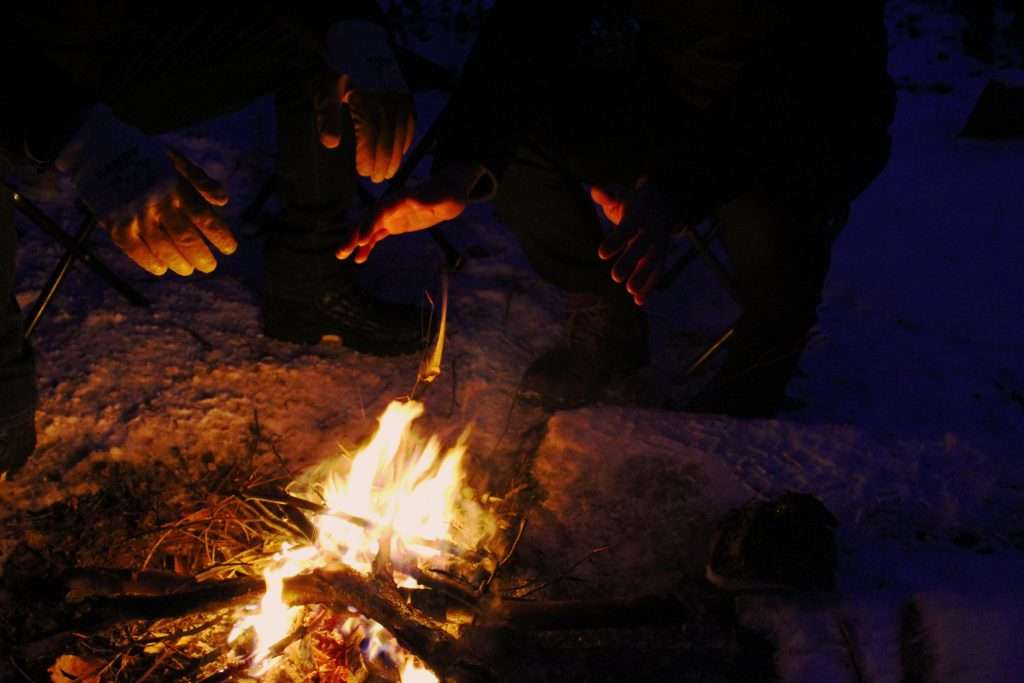 gente intorno ad un fuoco in campeggio