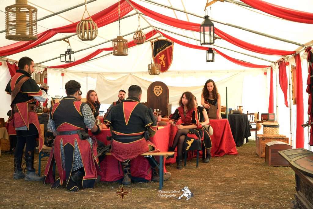 Gruppo larp intorno al tavolo con abiti e scenografia medievale